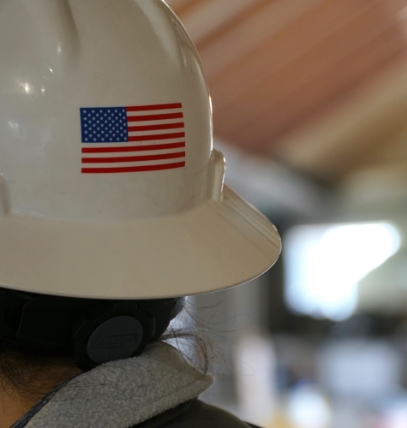 A smiling miners wearing a hard hat