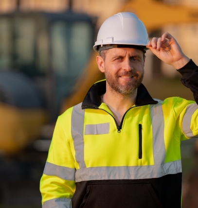 A smiling miners wearing a hard hat